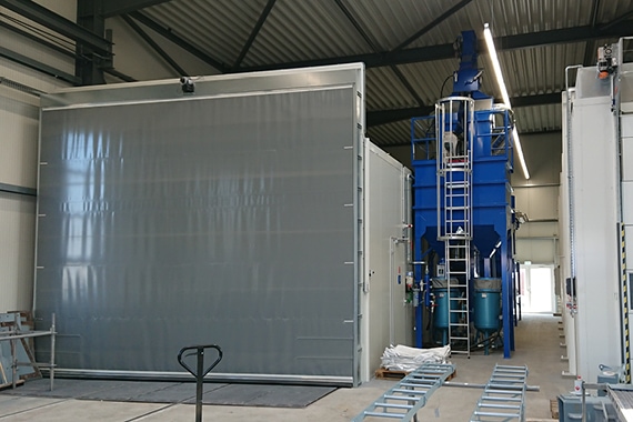 Strahlhalle (18x8x5mtr.) mit vollflächig Schrabberboden, Strahlmittelaufbereitungs- anlage mit automatischem Trennungssystem für zwei Strahlmittelsorten, Enstaubungssanlage, Beleuchtung und alle notwendigen Sicherheits-komponenten